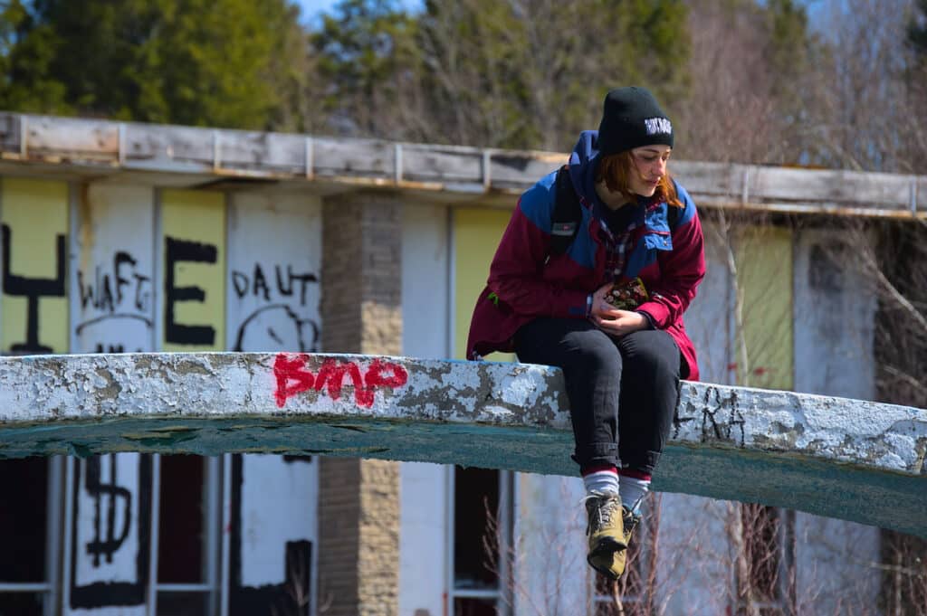 a person sitting on a concrete bridge/walkway at the pines resort